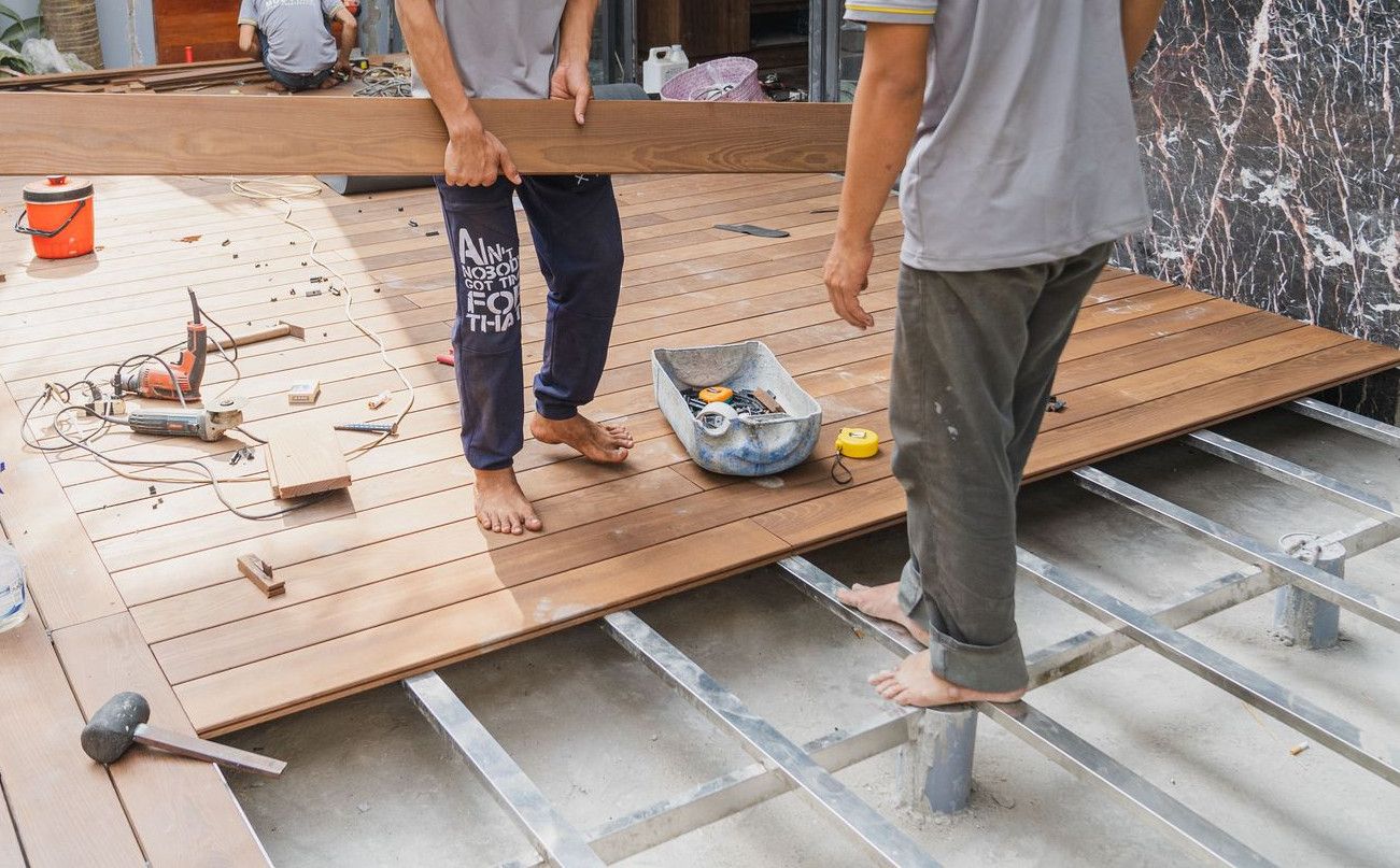 Carpenters working on a wooden floor installation in Hồ Chí Minh, Việt Nam.