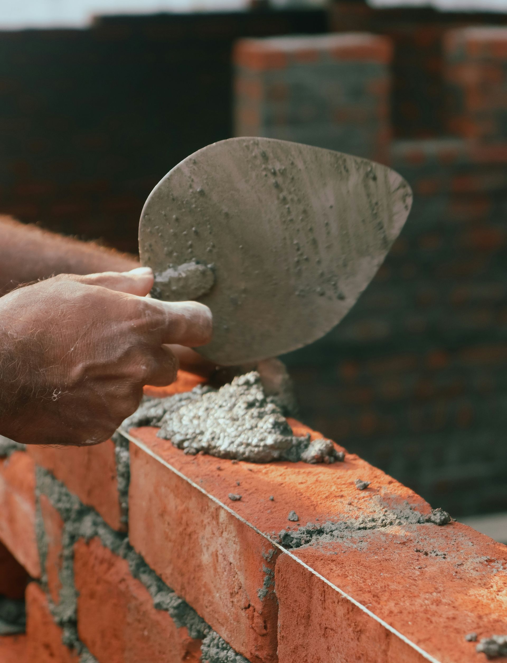 a brick wall being worked on with a trowe